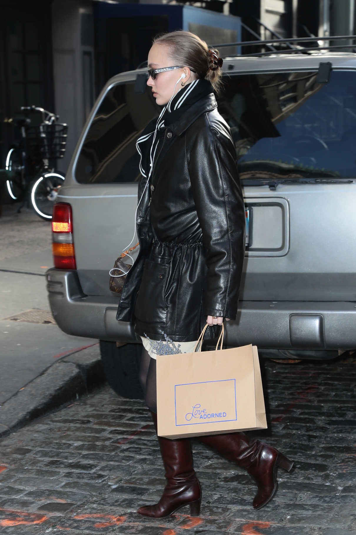 lily-rose depp steps out in a black leather jacket, brown knee high boots  and louis vuitton purse during a shopping trip in new york city-100219_4