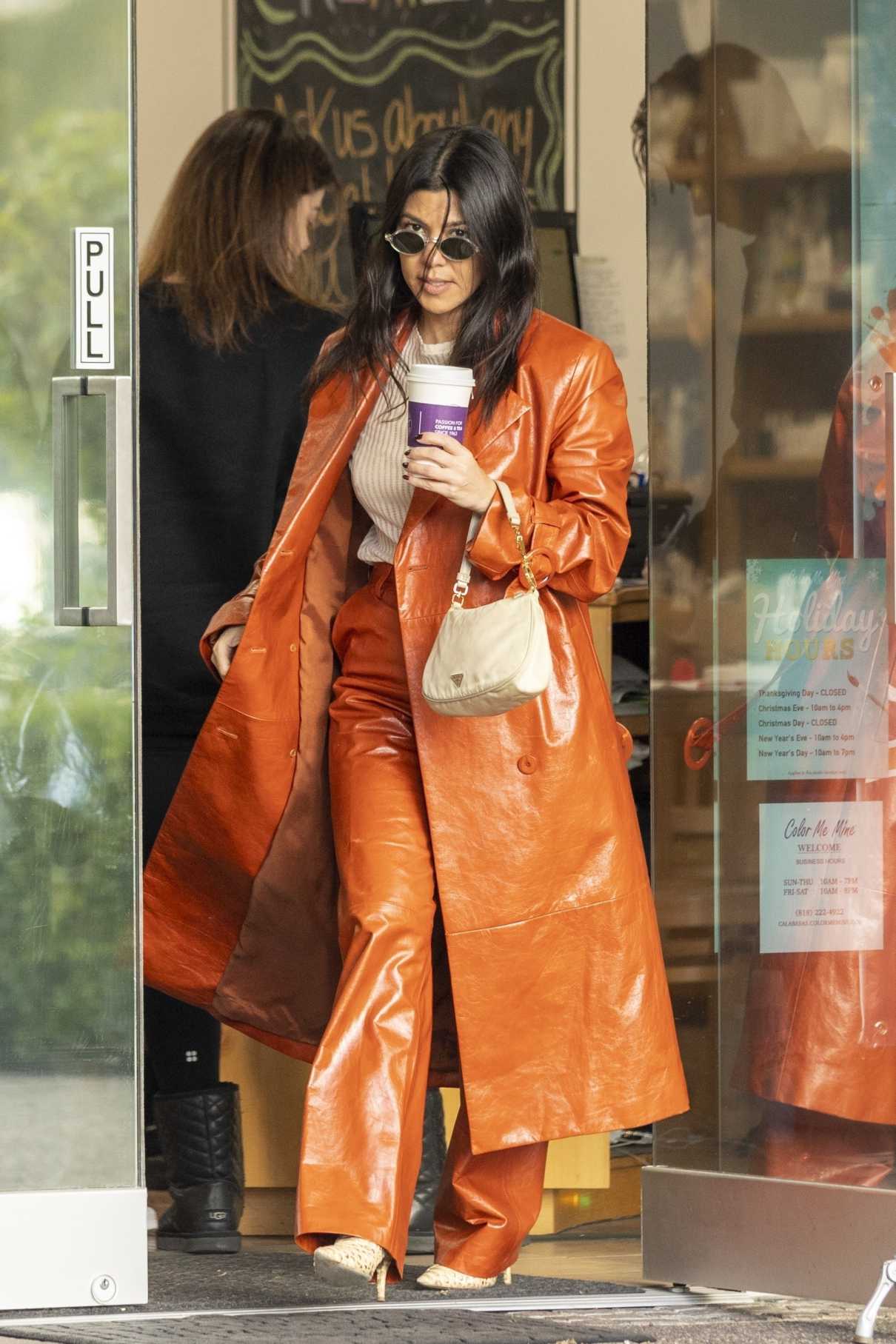 Kourtney Kardashian in an Orange Leather Trench Coat