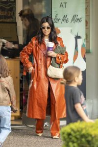 Kourtney Kardashian in an Orange Leather Trench Coat