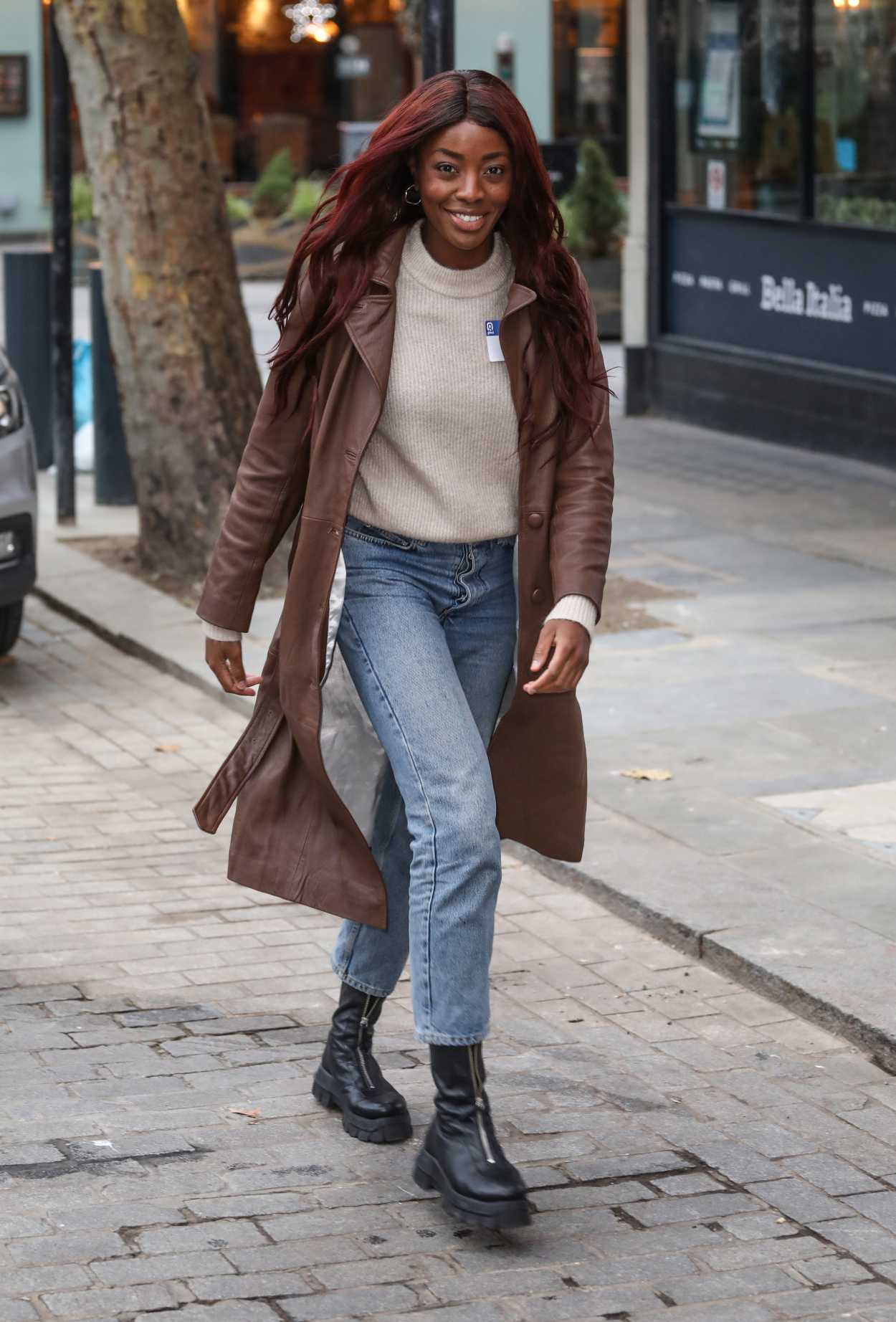 AJ Odudu in a Brown Leather Trench Coat