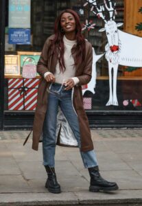 AJ Odudu in a Brown Leather Trench Coat