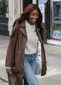 AJ Odudu in a Brown Leather Trench Coat