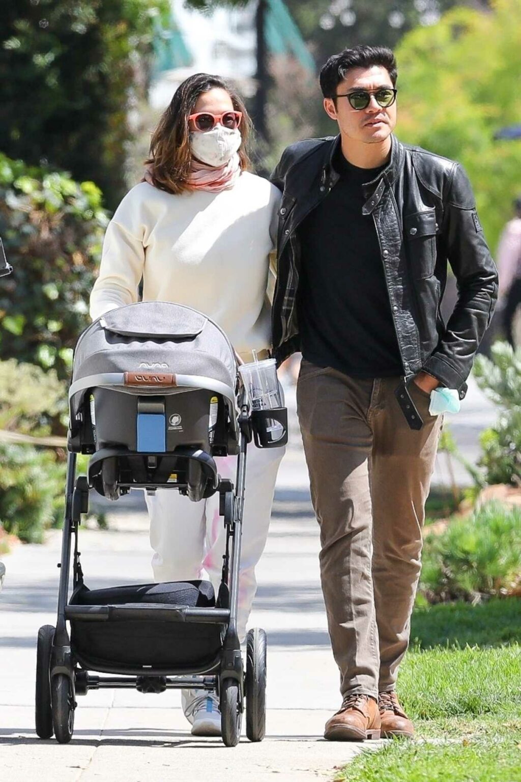 Henry Golding in a Black Leather Jacket Enjoys a Stroll with His Wife