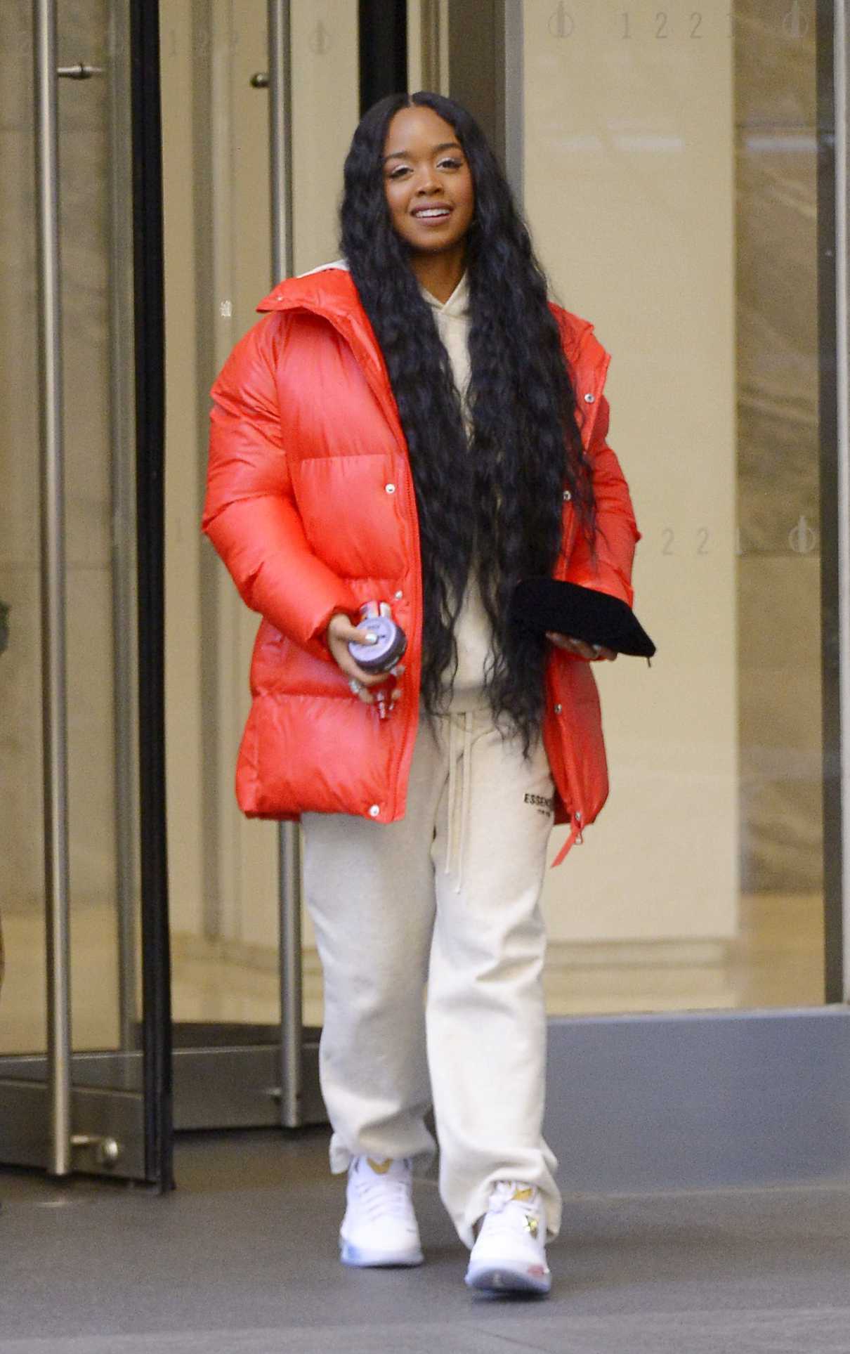 H.E.R. in a Red Puffer Jacket