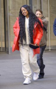 H.E.R. in a Red Puffer Jacket