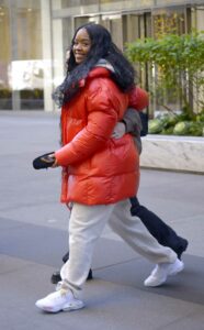 H.E.R. in a Red Puffer Jacket