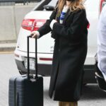 Margot Robbie in a Black Coat Arrives at JFK Airport in New York 02/11/2023