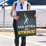 Joey King in a White Tank Top Attends the SAG-AFTRA and WGA Strike at the Warner Bros Studio in Los Angeles 07/14/2023