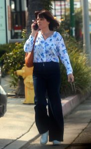 Neve Campbell in a White Floral Print Blouse